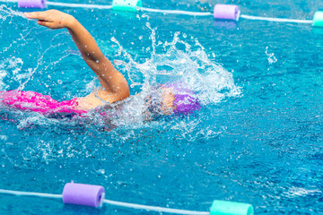 Young girl swimmer working on her freestyle swim at a local pool