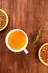 An overhead photo of herbal tea on a dark rustic background with a place for text