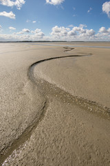 Litlle river flowing on the beach into sea, Somme Bay, Picardy, France.