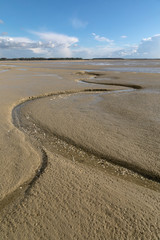Litlle river flowing on the beach into sea, Somme Bay, Picardy, France.
