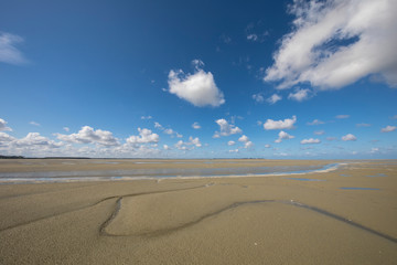 Litlle river flowing on the beach into sea, Somme Bay, Picardy, France.