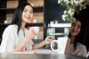 young businesswoman working with mobile laptop and holding coffee cup in office, business concept