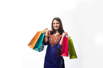 Portrait of a happy Indian woman or young girl carrying shopping bags, isolated over white background
