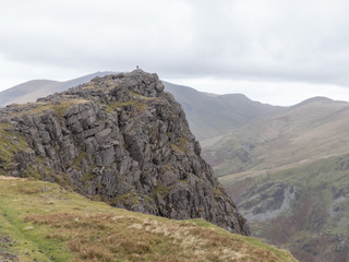 Fototapeta na wymiar A hiker stands high atop a huge rock
