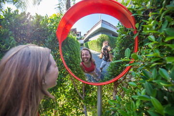 Two funny peoples make photo in road car mirror