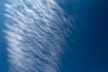 Shapes on blue sky with clouds.