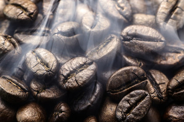 Fresh roasted coffee beans with steam. Coffee beans background. Coffee aroma.