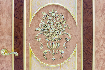Entrance door with gilded trim and floral designs.