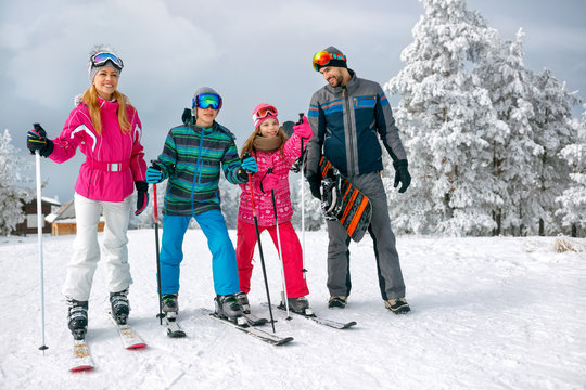 family with ski and snowboard on ski holiday in mountains