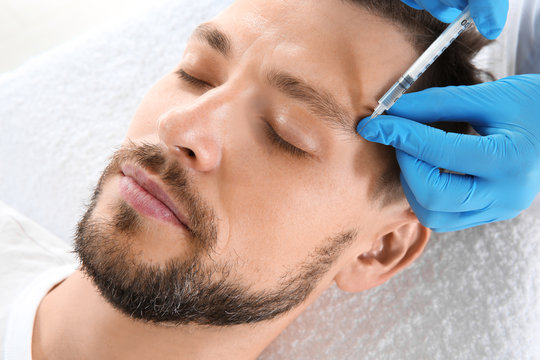 Man getting facial injection in clinic. Cosmetic surgery concept