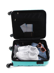 Open suitcase packed for travelling on white background