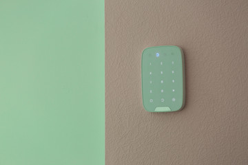 Alarm system keypad hanging on wall indoors