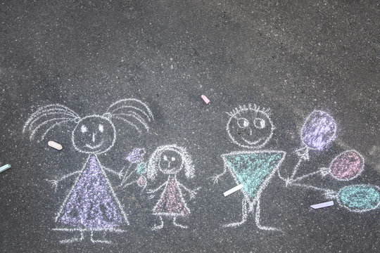 Child's chalk drawing of family on asphalt, top view