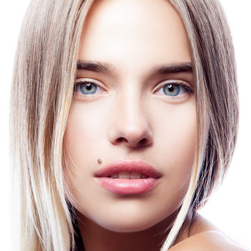 Close-up beauty face of youngmodel girl with healthy clean fresh skin, natural make-up, blond hair, blue eyes. Skincare facial treatment concept