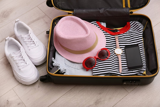 Packed suitcase on wooden background. Summer vacation