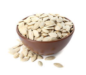 Raw pumpkin seeds in bowl on white background