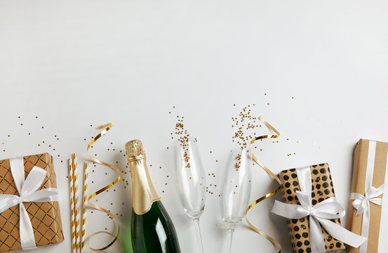 Creative flat lay composition with bottle of champagne and space for text on white background