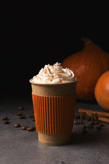 Paper cup with tasty pumpkin spice latte on gray table