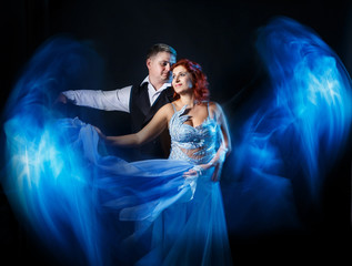 Couple man and woman husband and wife dancing having fun in darkness on the black background