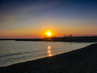 orange sunset over the bay and the mall