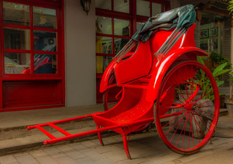 A bright red rickshaw in a back alley in a Beijing hutong - 1