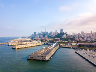 Beautiful aerial view of the San Francisco docks with many piers including pier 39 and Alcatraz prison in the middle of the bay.
