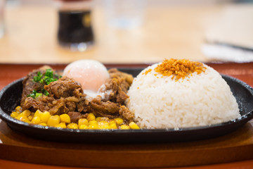 Pork teppanyaki with egg and corn in hot plate
