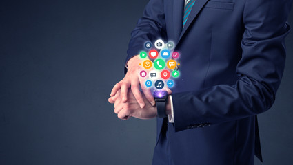 Businessman wearing smartwatch with colored application symbols on it.