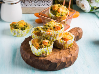 Home made healthy vegetable muffins with carrots and broccoli on wooden board. Corn breading