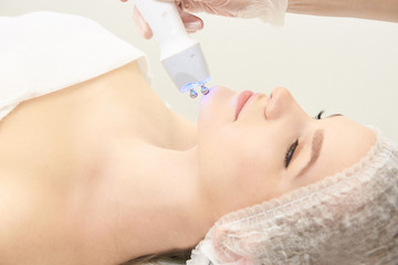 Naklejka premium Facial micro current cosmetology procedure. Beauty technology treatment. Woman face therapy