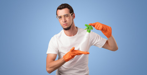 Housekeeper with cleaning product and equipment in front of a blue empty wall
