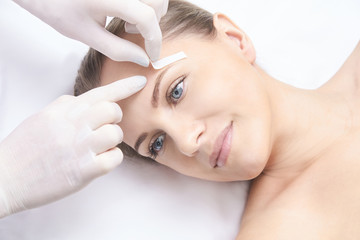 Obraz na płótnie Canvas Unwanted hair wax epilation. Young Woman. cosmetology salon treatment procedure. Home waxing