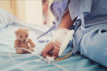 Mother holding child's hand who fever patients in hospital to give encouragement