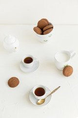 Breakfast on white table, tea and biscuits