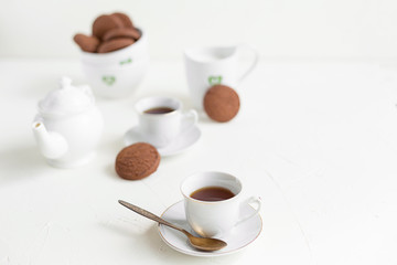 Breakfast on white table, tea and biscuits