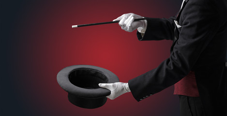 Illusionist white hand wants to conjure with magic wand from a black cylinder something © ra2 studio