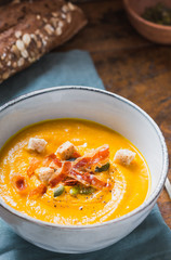 Pumpkin cream soup bowl.Roasted pumpkin soup with pumpkin seeds and wooden background.