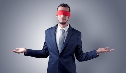 Covered eye, indecisive businessman standing blind in front of a wall