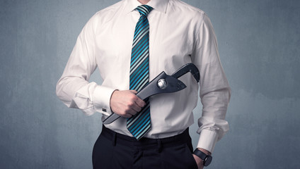 Young, handsome, cute businessman holding tool with grey background