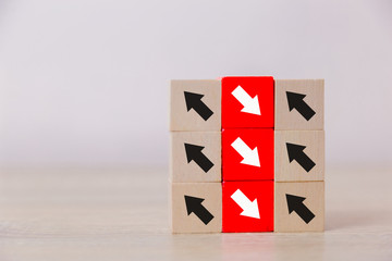 Red wooden blocks with white arrows facing opposite to the black arrows. With different concepts to...