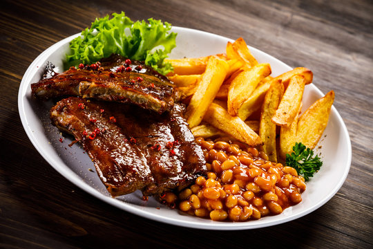 Tasty grilled ribs with french fries vegetables