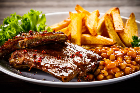 Tasty grilled ribs with french fries vegetables