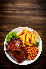 Tasty grilled ribs with french fries vegetables