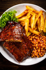 Tasty grilled ribs with french fries vegetables