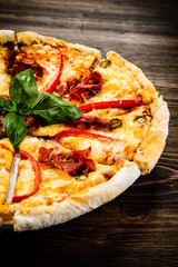 Pizza with ham and pepper on wooden table