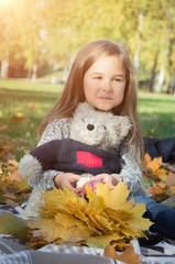 childhood concept: cute little girl in autumn park