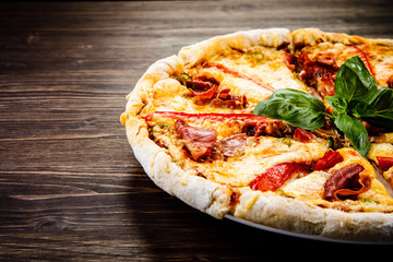 Pizza with ham and pepper on wooden table