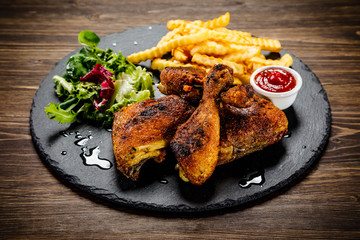 Grilled chicken legs with french fries and vegetables
