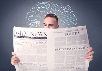 Puzzled young businessman reading daily newspaper with speech bubbles above his head