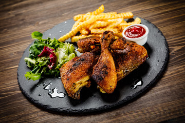 Grilled chicken legs with french fries and vegetables